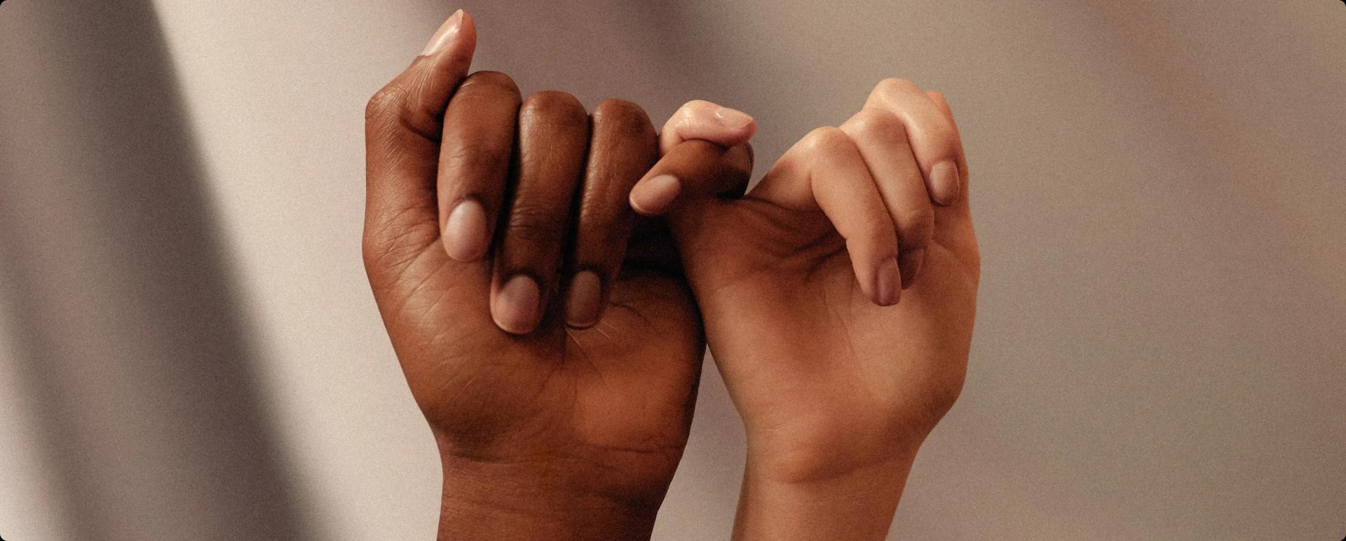 Two hands linked by their little fingers