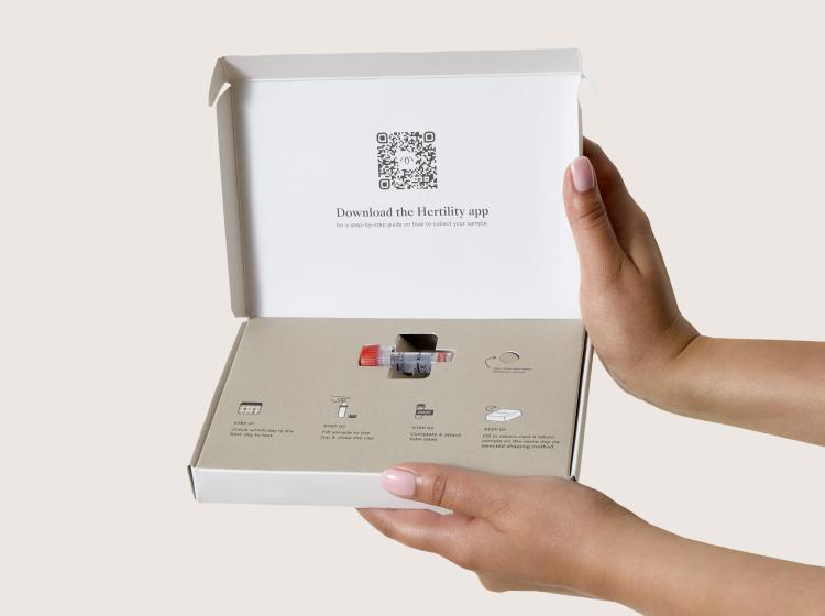 Hands holding open a Hertility test kit box